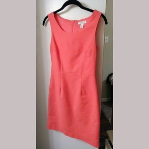 Coral color sheath style dress.
